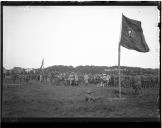 Militares em acampamento com bandeira portuguesa em primeiro plano.