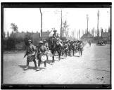 Coluna militar apeada acompanhada por militar a cavalo.