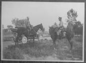 Dois militares a cavalo junto a viatura automóvel.