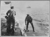 Dois militares em cima de submarino.