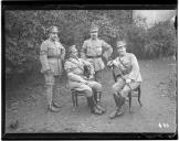 Grupo de quatro oficiais, dois sentados e dois em pé.
