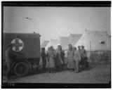 Grupo de militares junto a ambulância e a hospital de campanha.