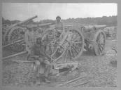 Primeiro plano de soldados do Exército Colonial junto a peças de artilharia.