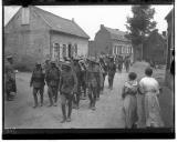 Militares a caminharem em formatura junto a edifícios militares.