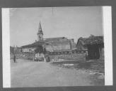 Ruínas em aldeia com campanário bombardeado.