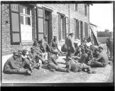 Militares sentados junto a edifício.