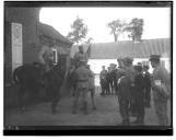 Militares a cavalo e apeados junto a crianças.