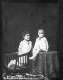 Duas crianças estando uma em cima da mesa.
