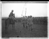 Oficial a cavalo com militares formados à sua frente.