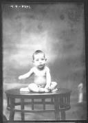 Criança sentado numa mesa.