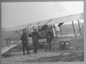 Três militares com avião na retaguarda.