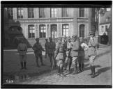 Grupo de militares em frente a edifício comercial.