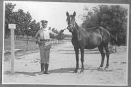 Tratador com cavalo de cor escura, identificado com o número 4.