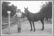 Tratador com cavalo de cor escura, identificado com o número 30.