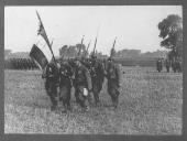 Militares em desfile com a bandeira do regimento.