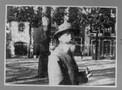 Civil do sexo masculino com chapéu, barba e cachimbo em jardim público.