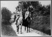 Dois militares a cavalo.