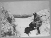 Militar com cão em zona de neve.
