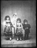 Quatro crianças, estando as menimas com traje tradicional Minhoto.