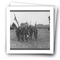 Militares em desfile com a bandeira do regimento.